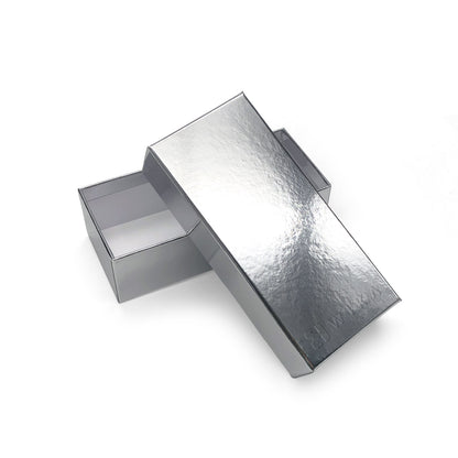Silver-finish box with lid resting diagonally beside the base